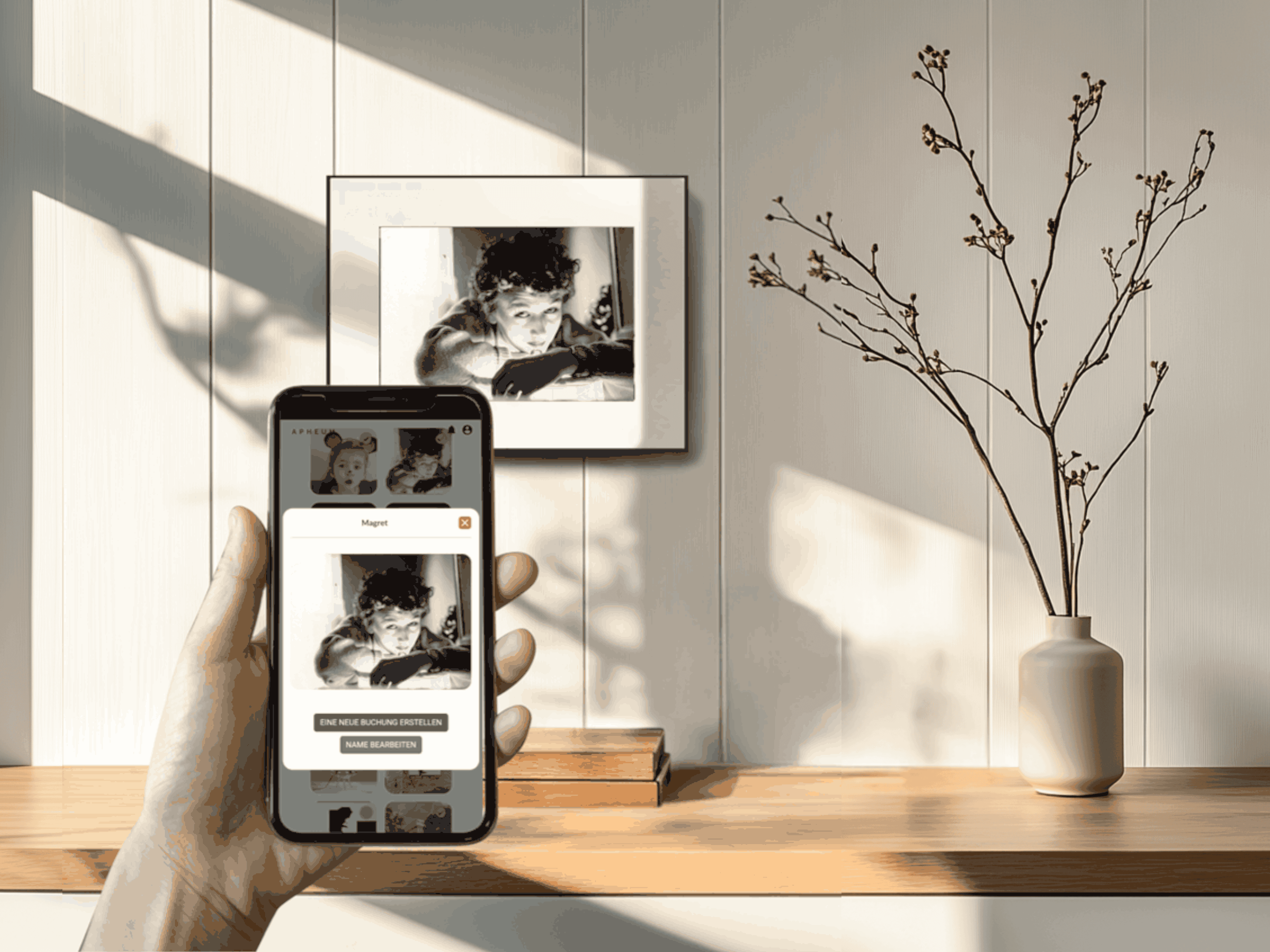 Mobile Device mit geöffneter Apheum App, im Hintergrund eine Holzwand mit aufgehängtem Apheum Frame M