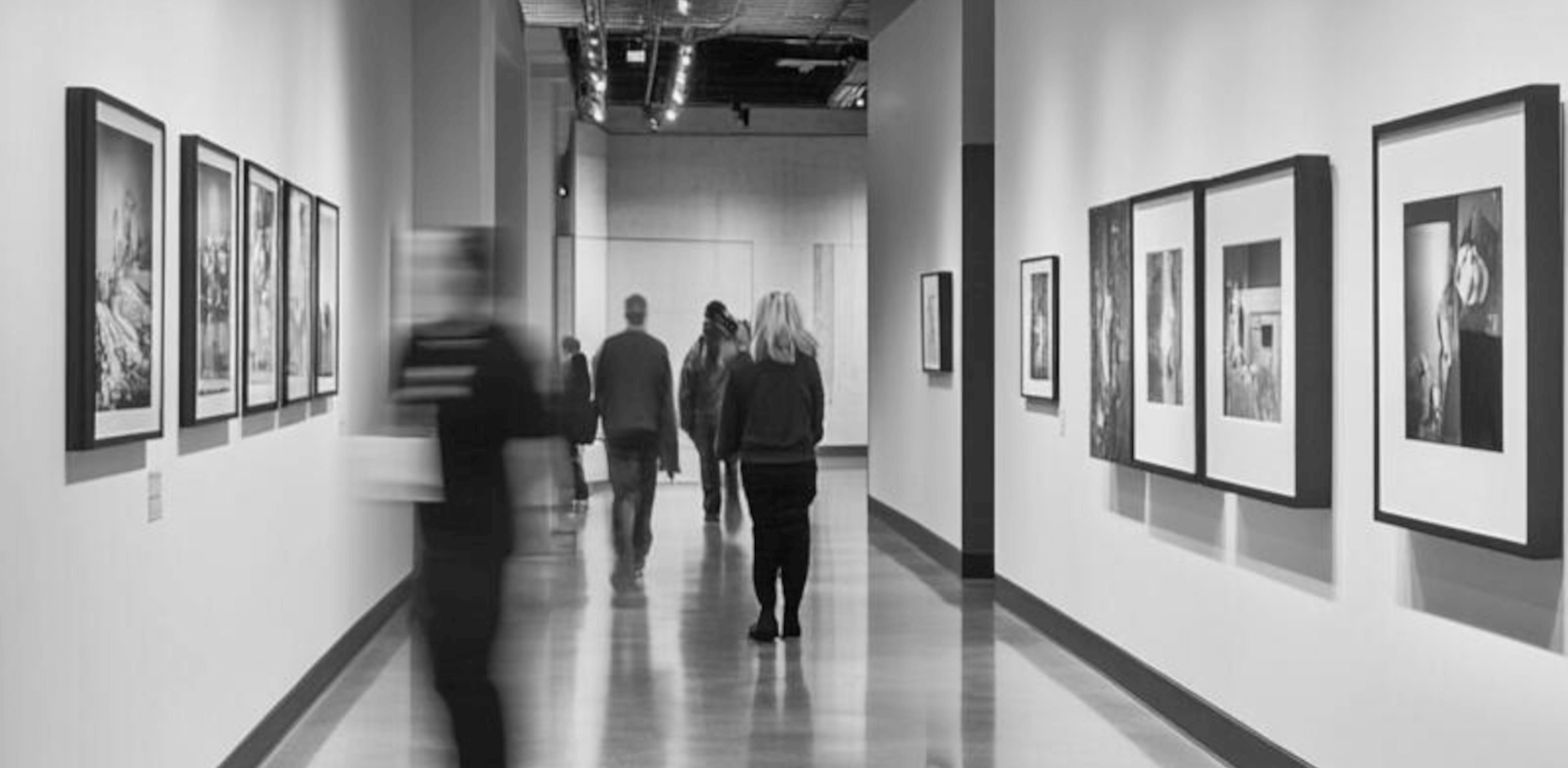 Blick in einen Ausstellungsgang mit Bilderrahmen an den Wänden