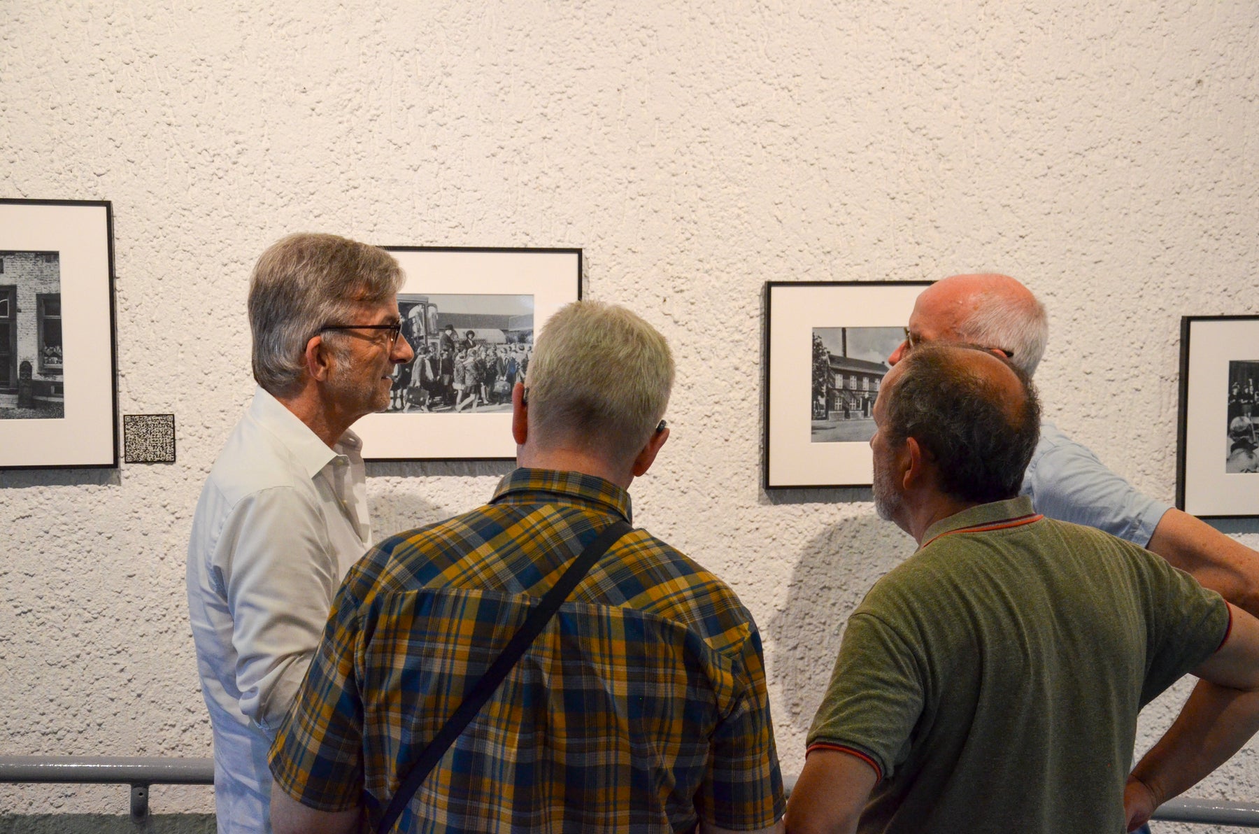 Besucher lesen und besprechen die Geschichten zu historischen Fotografien im Rathaus Schwalmtal.